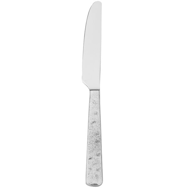 A silver Walco Vestige table knife with a white handle.
