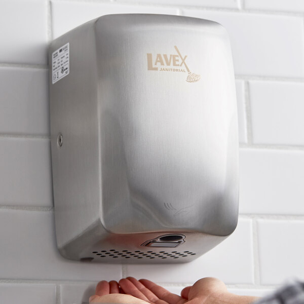 A Lavex stainless steel automatic hand dryer in a kitchen with white tile walls.