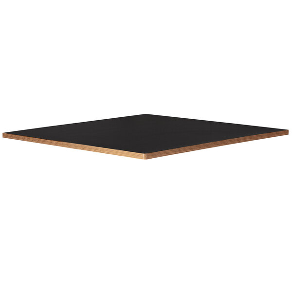 A black square Bon Chef table top on a wooden table base.