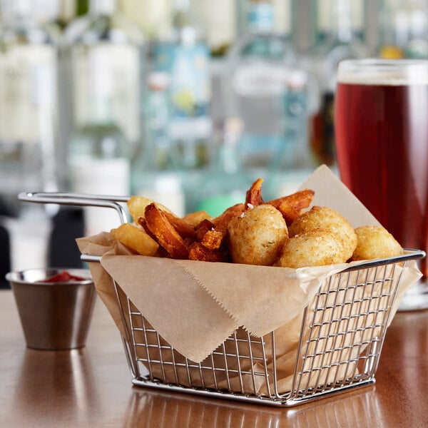 A rectangular mini fry basket filled with fries on a table.
