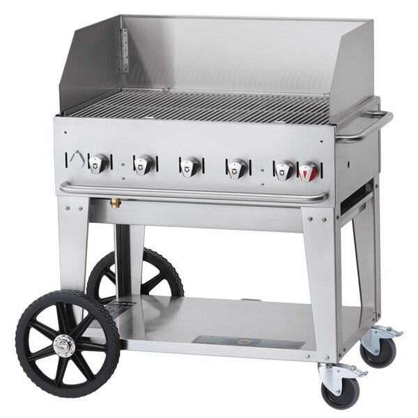 A Crown Verity liquid propane outdoor grill on a stainless steel cart with a wind guard.