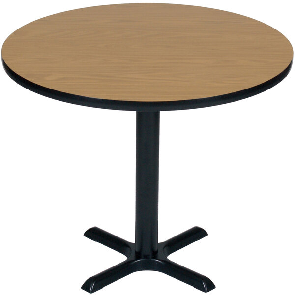 A Correll round table with a medium oak finish and black base.