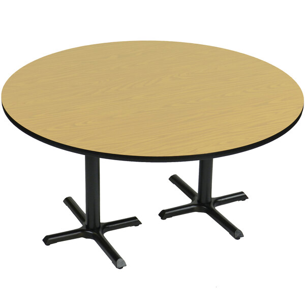 A Correll round table with a Fusion Maple finish and black cross bases.