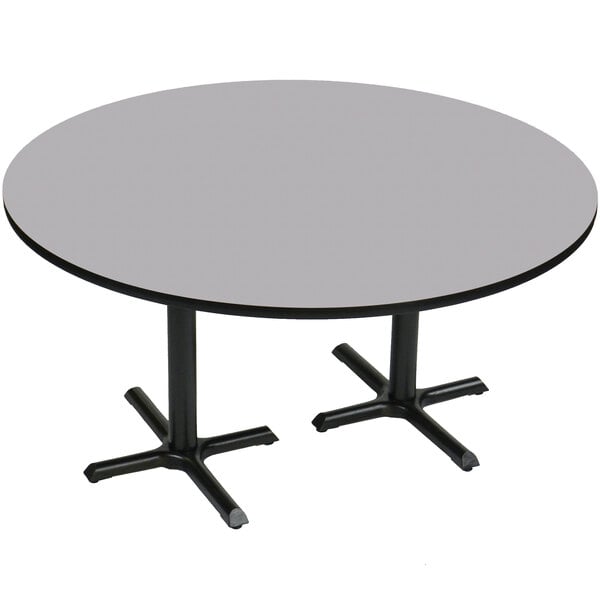 A Correll round table with gray granite finish and two black metal cross bases.