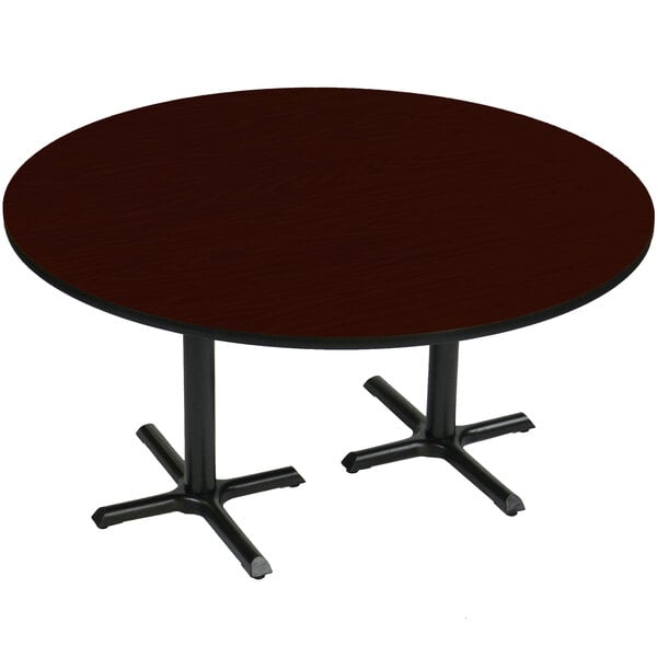 A Correll round mahogany table with black cross bases.