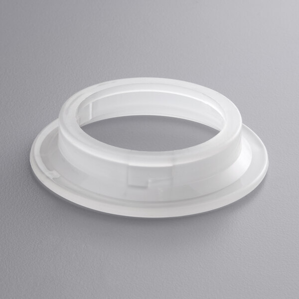 A white plastic flange with a hole.