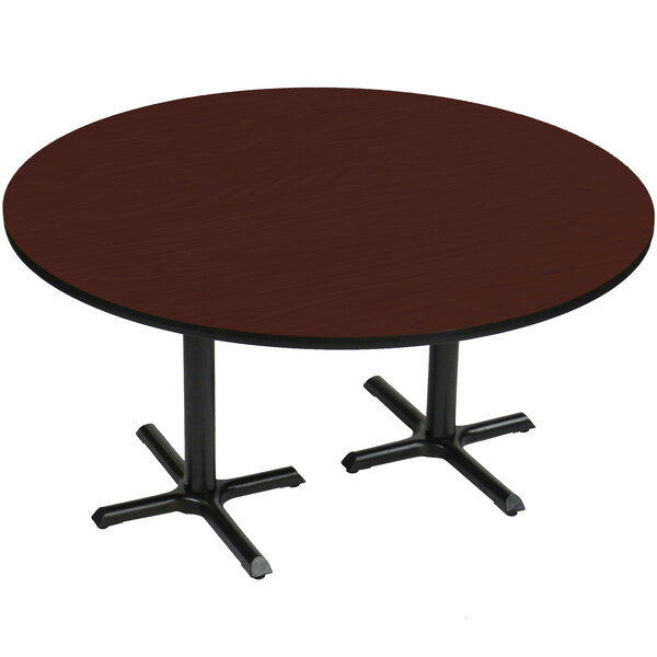 A Correll round table with cherry finish and two black cross bases.