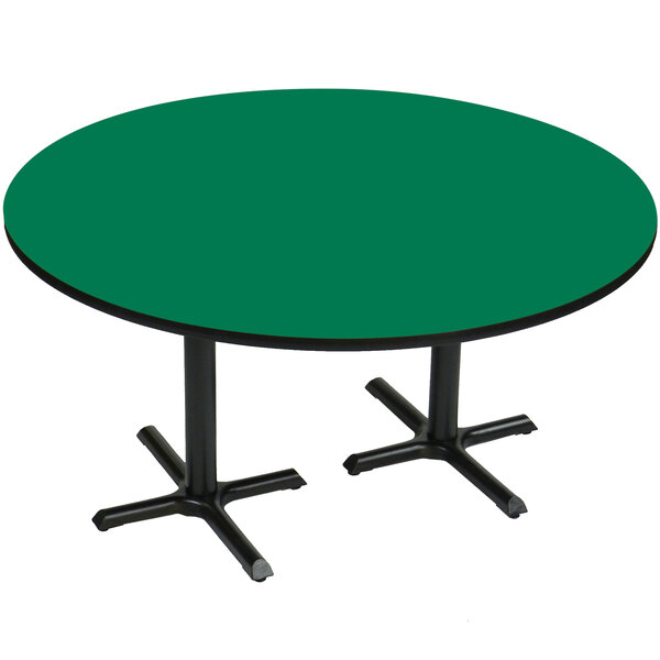 A green table with black cross bases.
