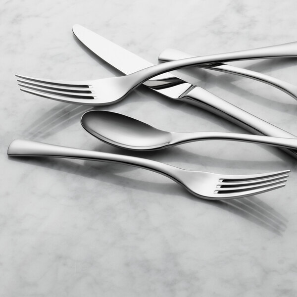 A set of Reserve by Libbey Lucine stainless steel salad forks on a marble surface.