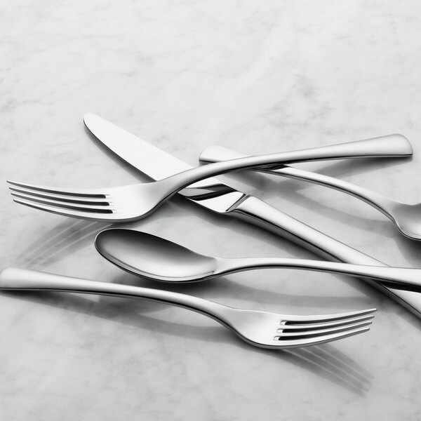 A set of Reserve by Libbey stainless steel dinner forks on a white surface.