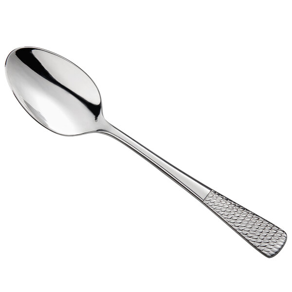 A stainless steel demitasse spoon with a textured handle.