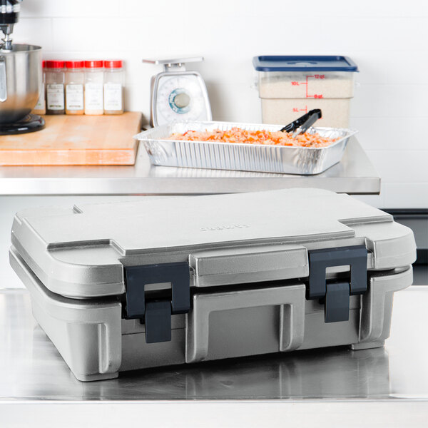 A granite gray plastic Cambro food pan carrier with a lid on a counter.