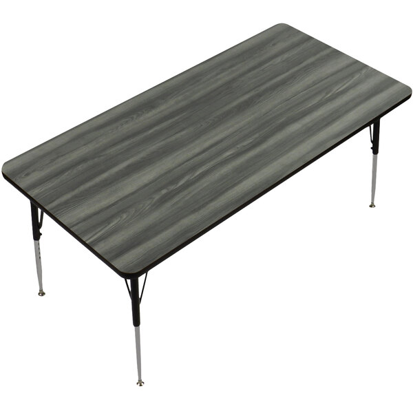 A rectangular New England driftwood finish table top on metal legs.