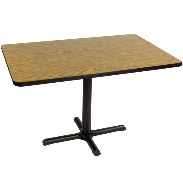 A Correll rectangular table with a medium oak top and black base.