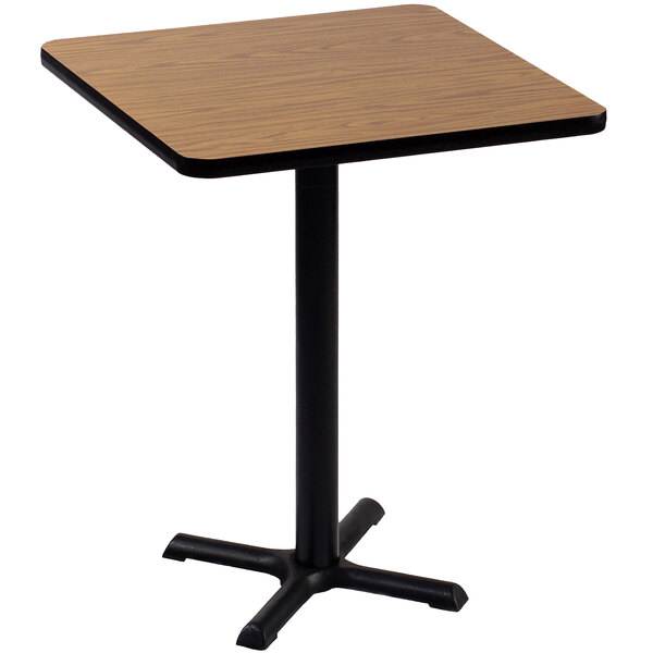 A Correll square table with a medium oak top and black base.
