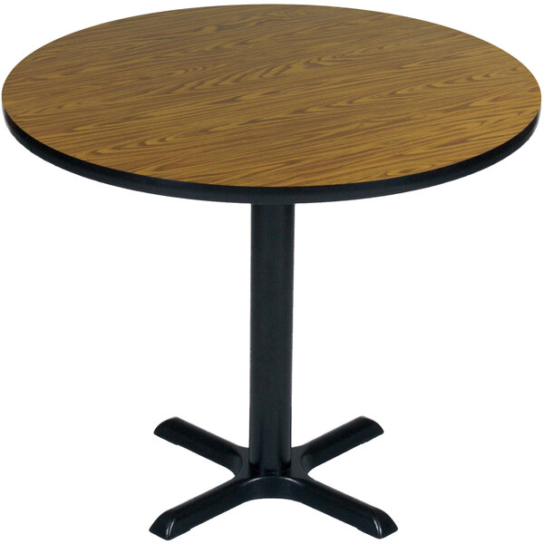 A Correll round table with a medium oak finish and black base.