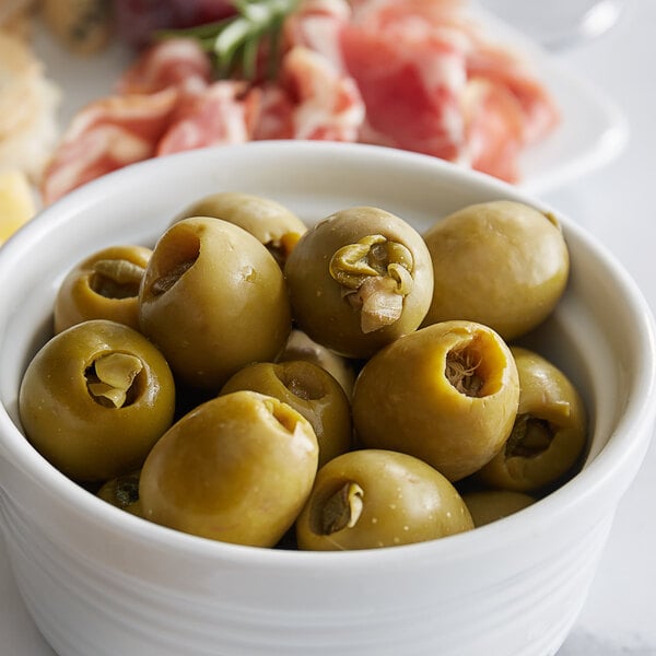 A bowl of Belosa Caper Stuffed Queen Olives on a table in a deli.