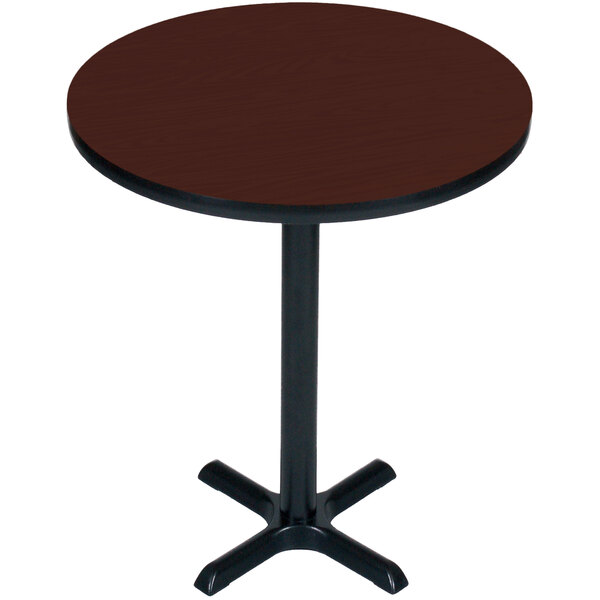 A round brown table with a black base.