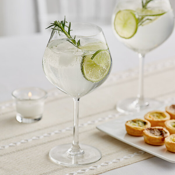 An Acopa Copa Gin and Tonic glass with a lime wedge in it.