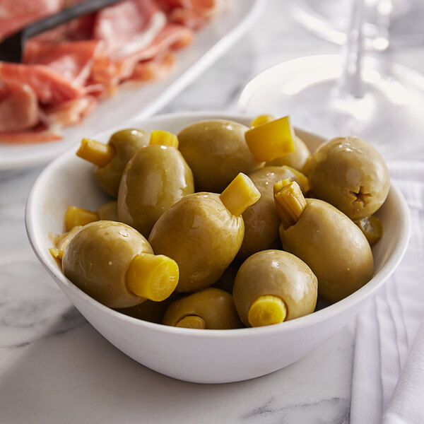 A bowl of Belosa asparagus stuffed green olives on a marble table.
