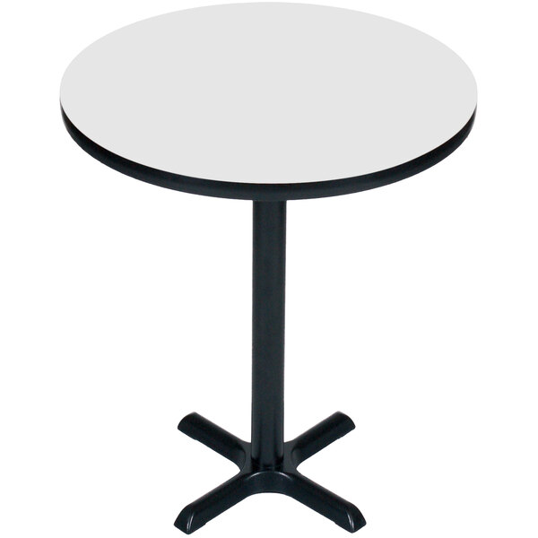 A round white table with a black base.