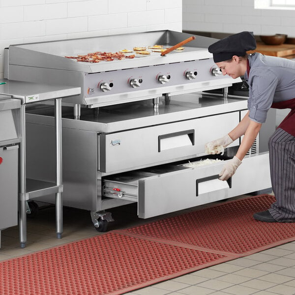 A chef using an Avantco 2 drawer refrigerated chef base to store food.