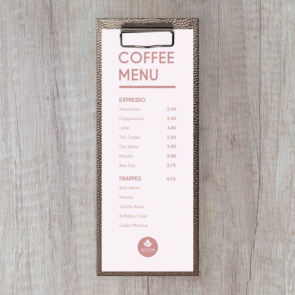 A customizable menu clipboard with a coffee menu on a wood surface.