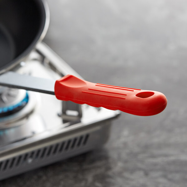 A red silicone sleeve on a pan handle.