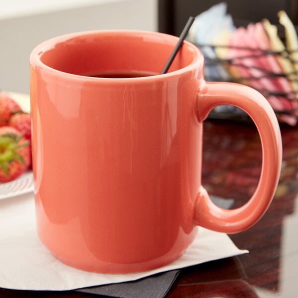 A Tuxton Cinnebar C-Handle mug filled with coffee and a black straw.