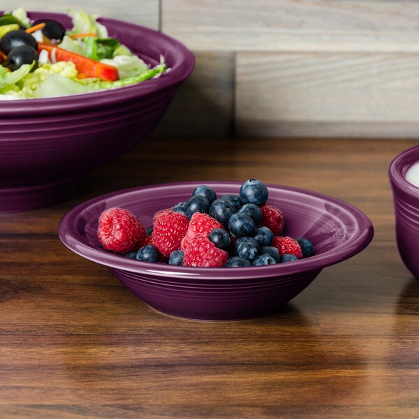A purple Fiesta china bowl filled with fruit