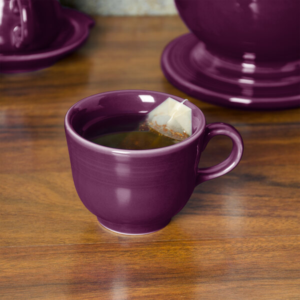 A purple Fiesta china cup with a tea bag in it.