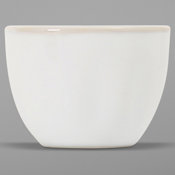 A white Tuxton China bouillon cup with a small white rim on a gray surface.