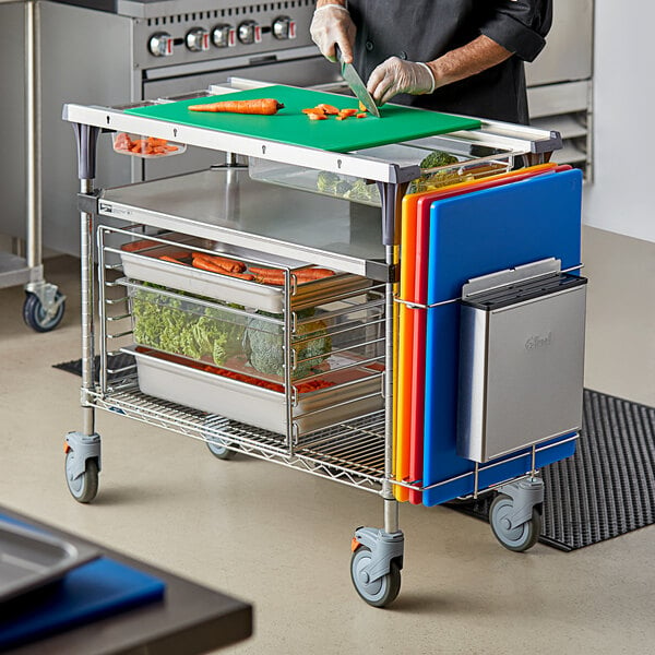 A chef uses a Metro PrepMate to cut vegetables on a cutting board.