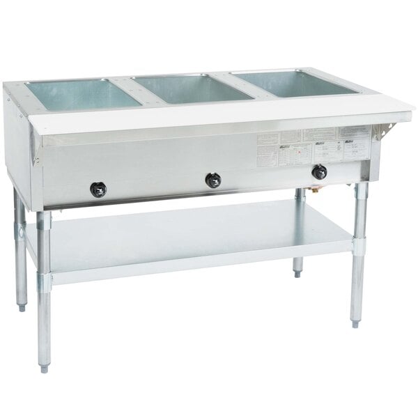An Eagle Group stainless steel liquid propane steam table warmer on a counter with three trays inside.