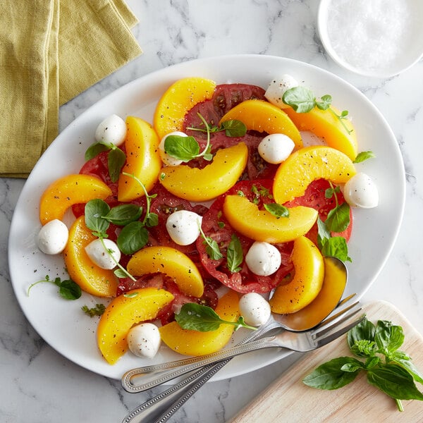 Sliced Del Monte yellow clingstone peaches in a white bowl.