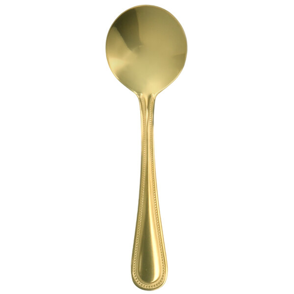 A close-up of a Walco gold stainless steel bouillon spoon with a white background.