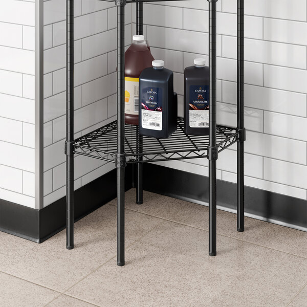 A black epoxy wire pentagon corner shelf designed for storage in commercial or residential spaces.