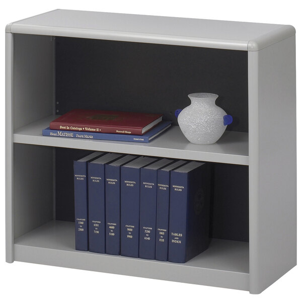 A gray Safco ValueMate bookcase with books and a vase on it.