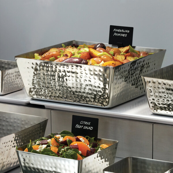A group of metal containers with a salad in one of them.