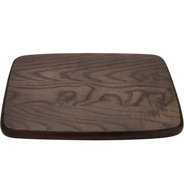 A GET Taproot ash wood serving board with rounded edges on a wood surface.