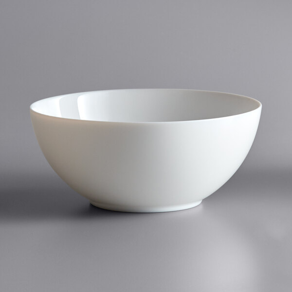 An Arcoroc white opal glass bowl on a gray surface.