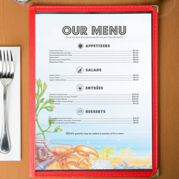 Menu paper with a seafood themed ocean design on a table with a fork and knife.