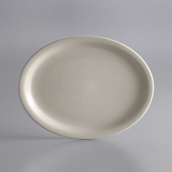 A white oval plate with a narrow rim on a gray surface.