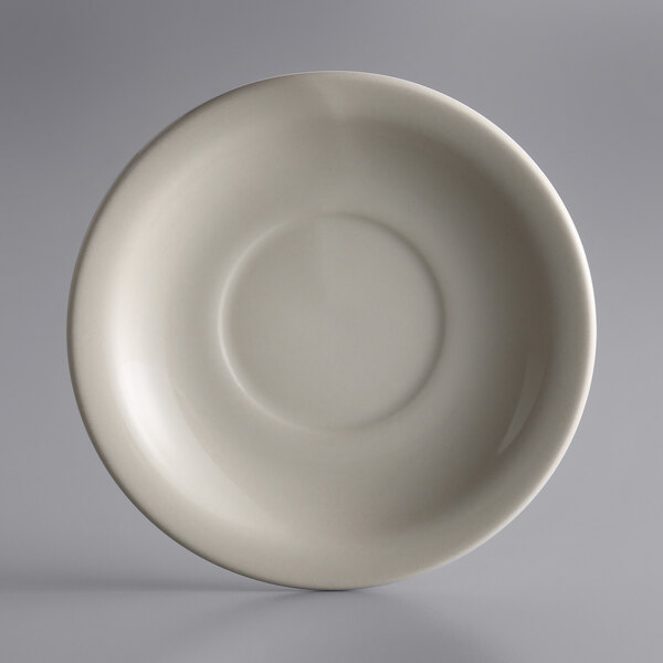 A white Libbey narrow rim stoneware saucer with a circle on it.