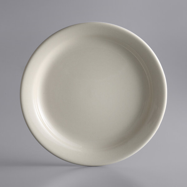A Libbey Kingsmen white stoneware plate with a narrow rim on a gray background.