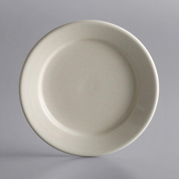 A close-up of a Libbey Princess White stoneware plate with a curved edge on a white background.