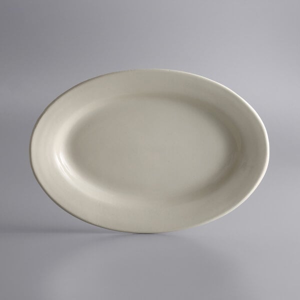 A white Libbey oval stoneware platter with a small rim on a gray background.