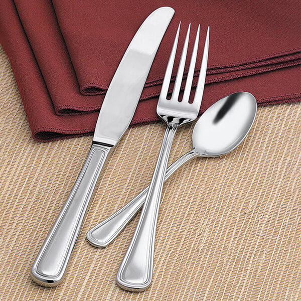 A Libbey stainless steel dinner knife and fork on a napkin.