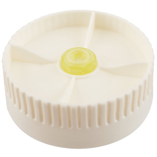 A white plastic cap with a yellow circle on it.