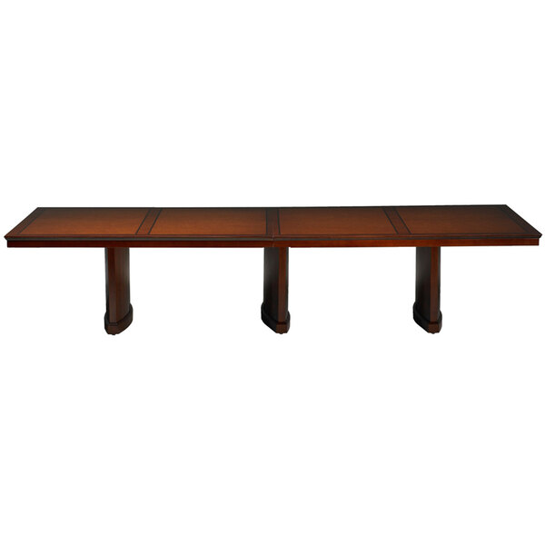 A long rectangular cherry conference table with four legs.